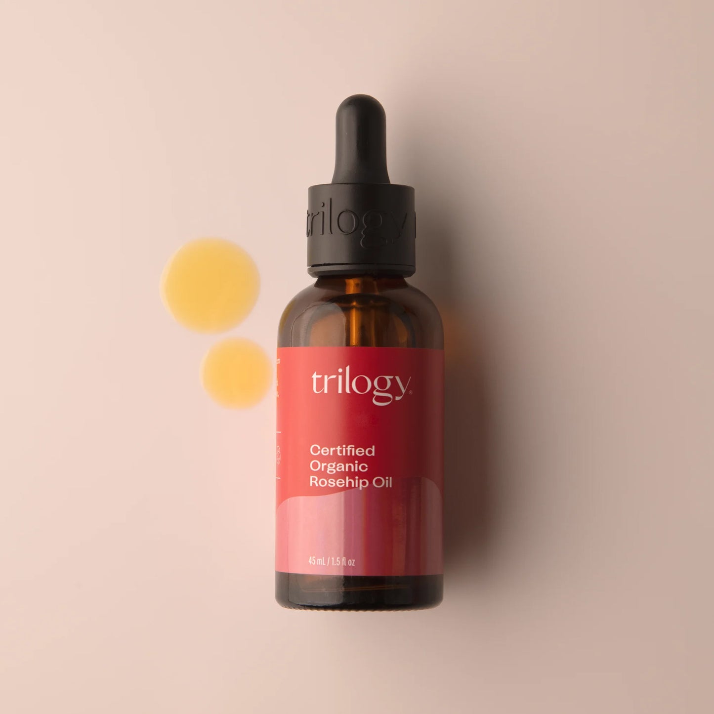 Trilogy organic rosehip oil dropper bottle on a beige background