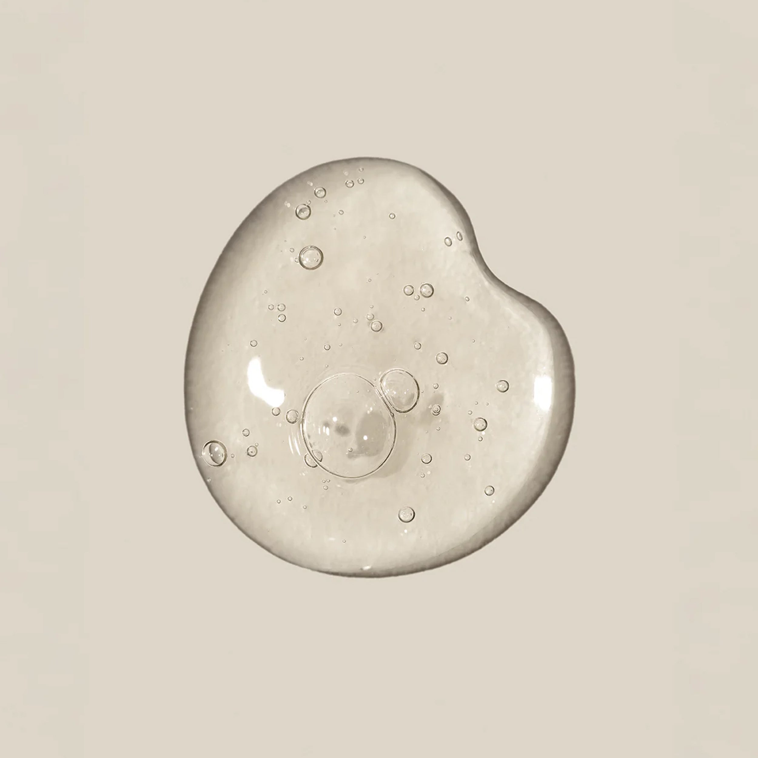 Clear gel or cream with bubbles on a beige background