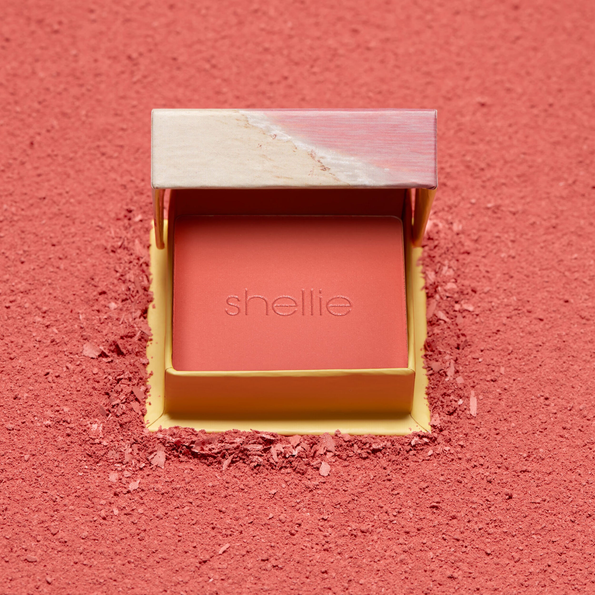Open blush compact with 'shellie' branding on a pink background