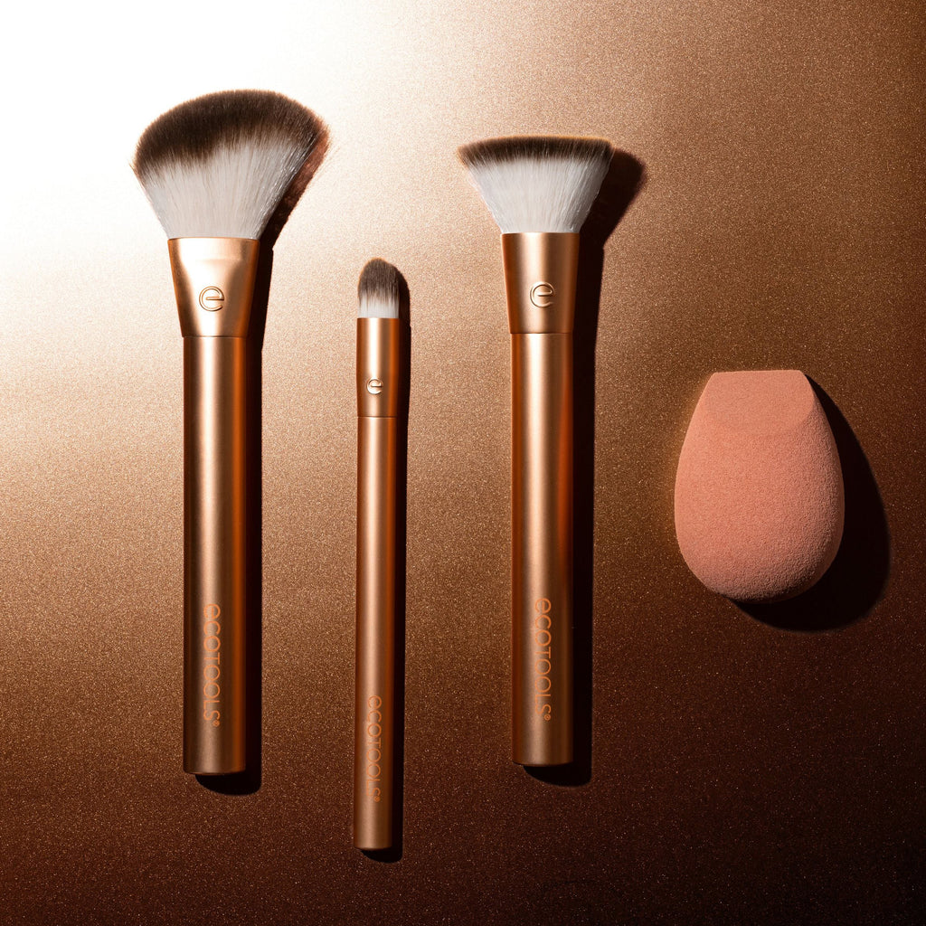 Set of makeup brushes and a sponge on a bronze background