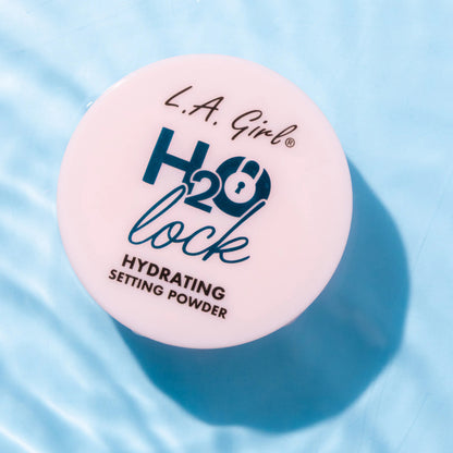 L.A. Girl H2O Lock hydrating setting powder container on a blue fabric background