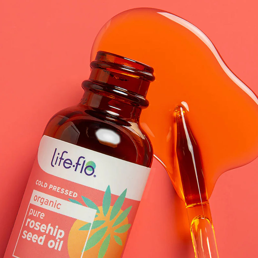 Life Flo organic pure rosehip seed oil bottle with dropper on a red background