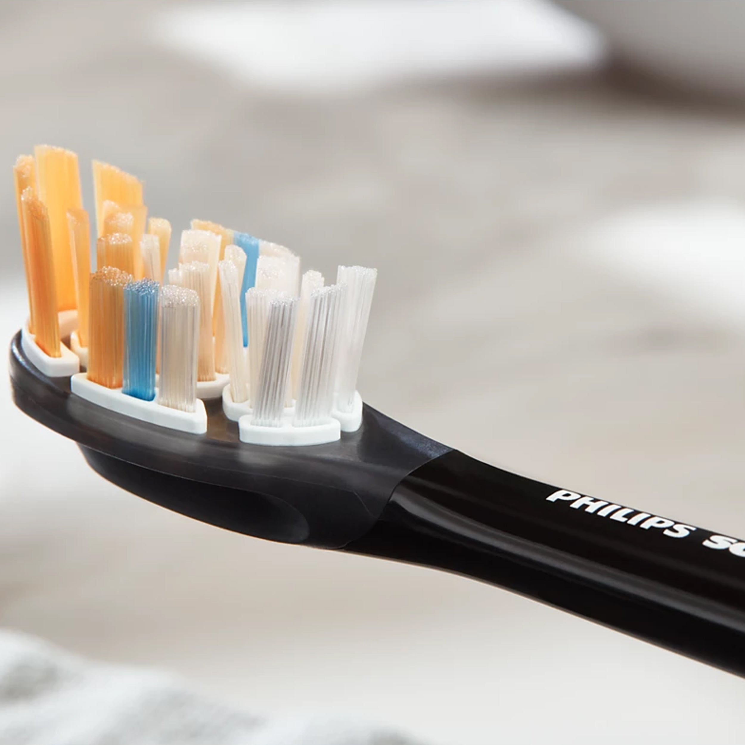 Philips Sonicare toothbrush with multiple brush heads on a neutral background