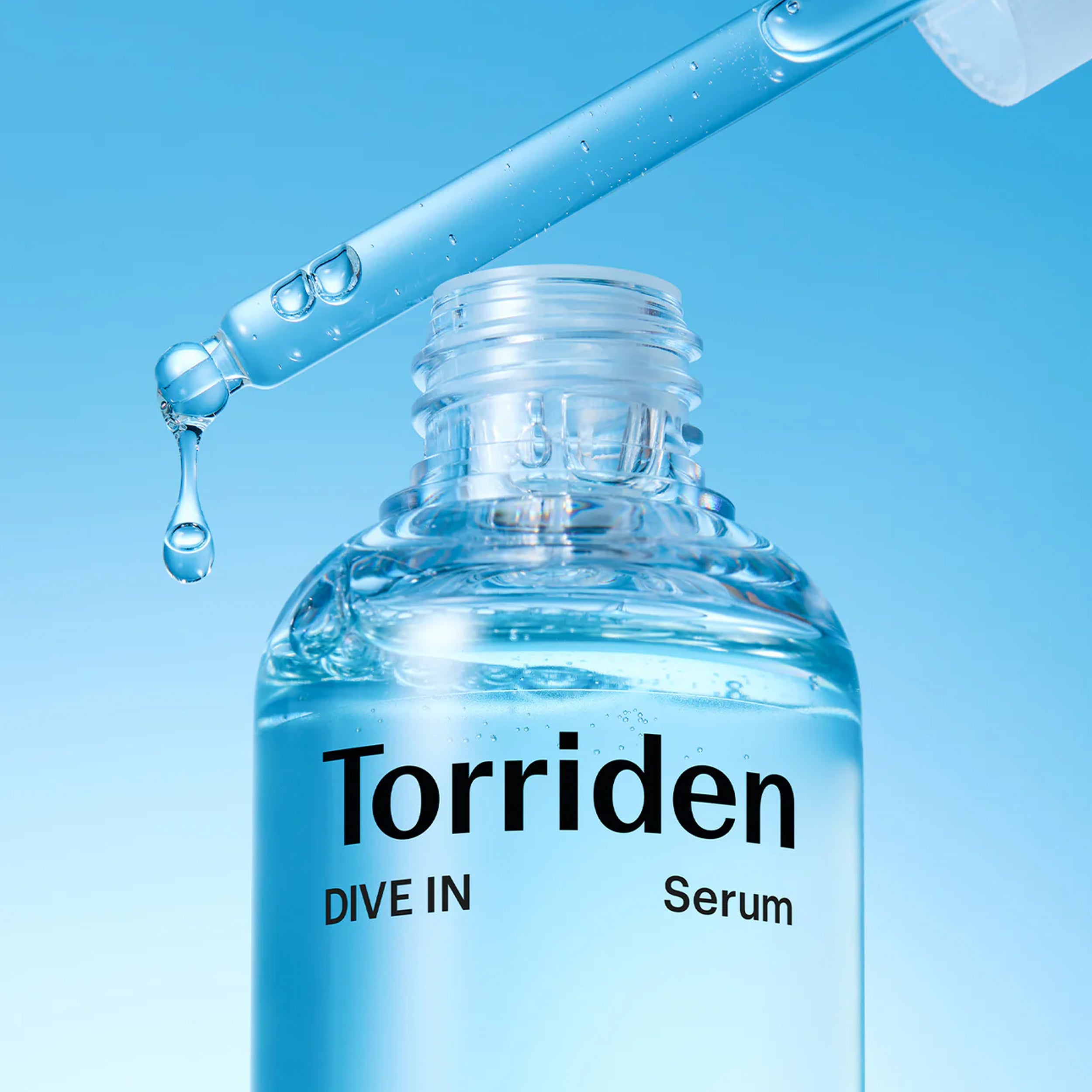 Torriden serum bottle with dropper on a blue background